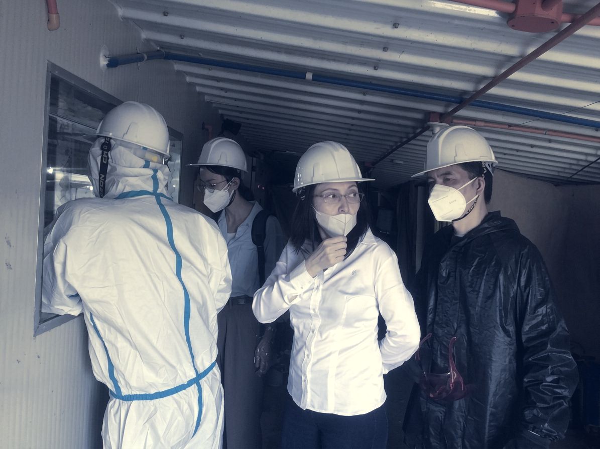 Team members in hard hats viewing the control room